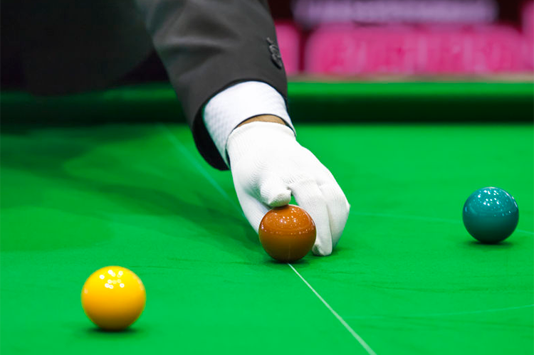 Adjusting snooker ball on snooker table